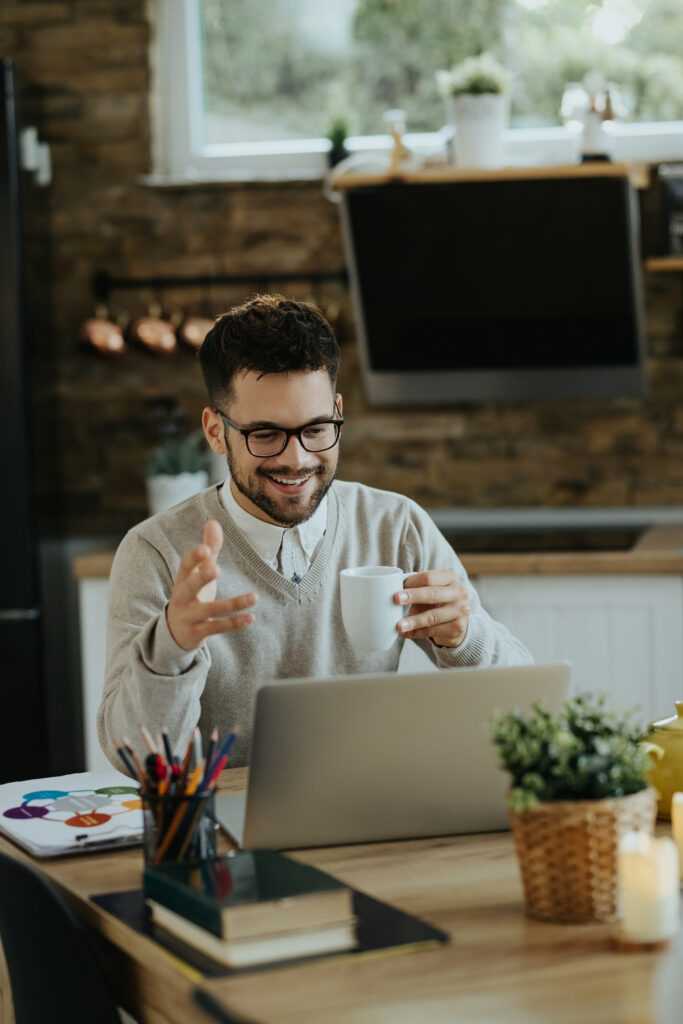 happy entrepreneur drinking coffee during conference call over l